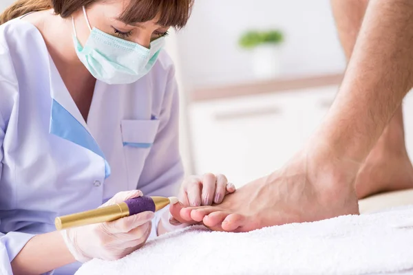 Podólogo tratando los pies durante el procedimiento — Foto de Stock