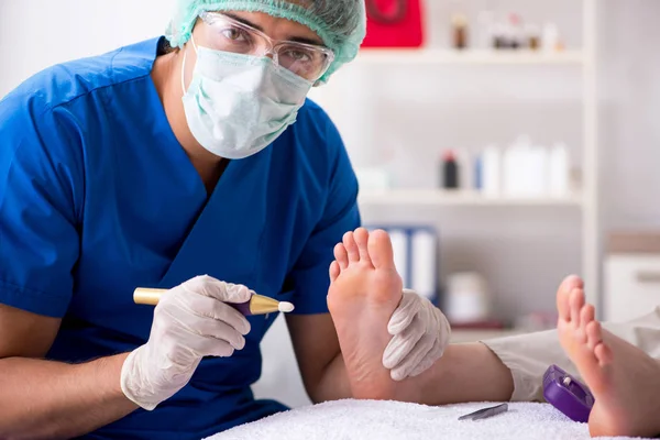 Podólogo tratando los pies durante el procedimiento — Foto de Stock