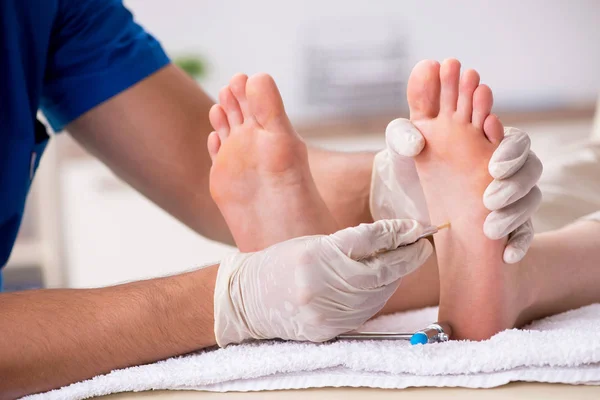 Podólogo tratando los pies durante el procedimiento —  Fotos de Stock