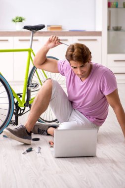 Kırık bisikletini tamir eden adam.