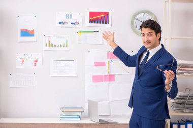 Genç yakışıklı satış elemanı ofiste çalışıyor.