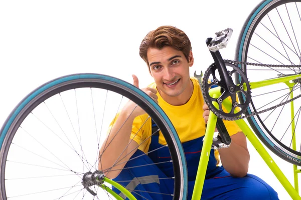 Homem reparando sua bicicleta isolada no fundo branco — Fotografia de Stock