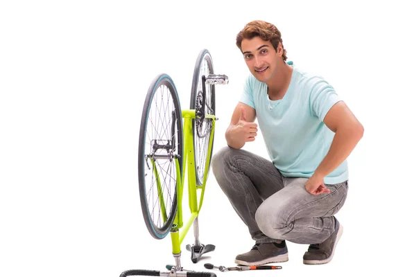 Homem reparando sua bicicleta isolada no fundo branco — Fotografia de Stock