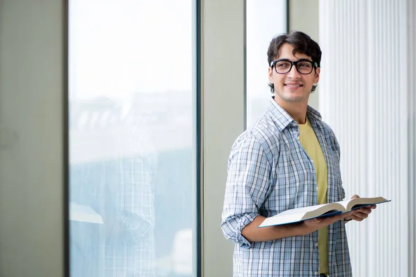 Joven estudiante guapo de pie en la ventana —  Fotos de Stock