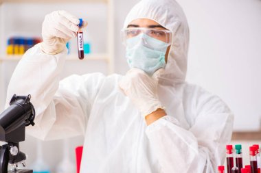 Genç yakışıklı laboratuvar asistanı hastanede kan örnekleri test ediyor. 