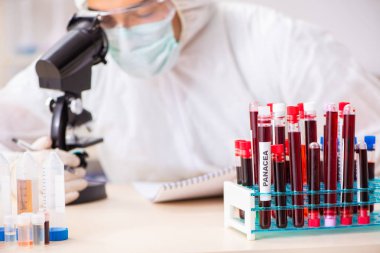 Genç yakışıklı laboratuvar asistanı hastanede kan örnekleri test ediyor. 