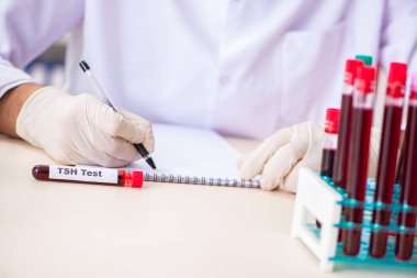 Genç yakışıklı laboratuvar asistanı hastanede kan örnekleri test ediyor. 