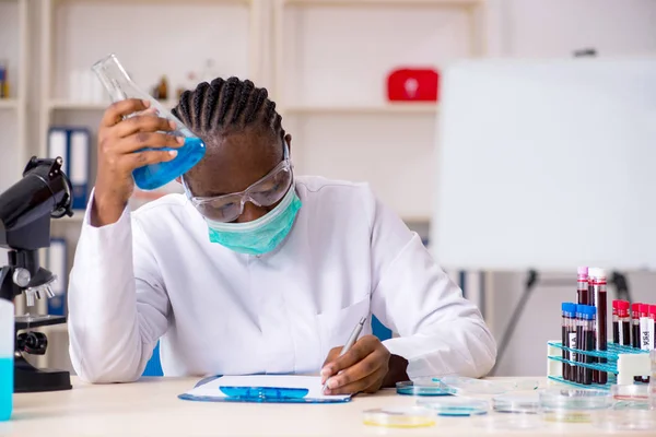 Jovem químico negro trabalhando no laboratório — Fotografia de Stock