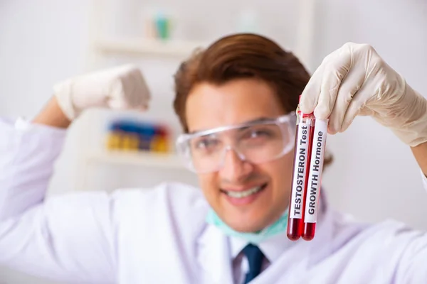 Młody przystojny asystent laboratoryjny badający próbki krwi w szpitalu — Zdjęcie stockowe