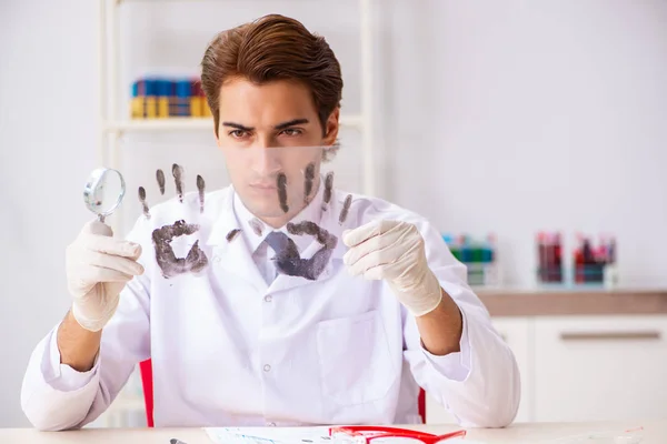 Судебный эксперт изучает отпечатки пальцев в лаборатории — стоковое фото