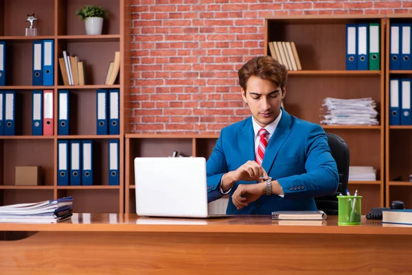 Joven empleado guapo sentado en la oficina — Foto de Stock