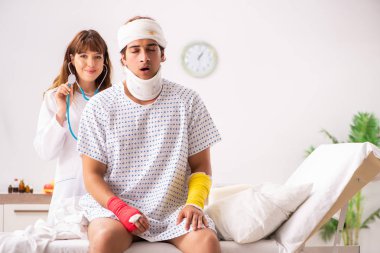 Genç doktor yaralı hastayı muayene ediyor. 