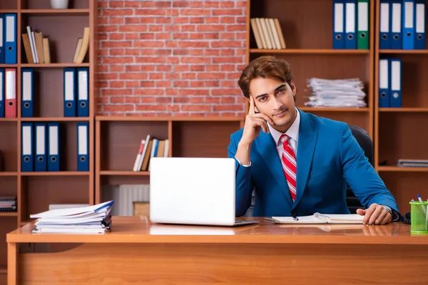 Joven empleado guapo sentado en la oficina — Foto de Stock