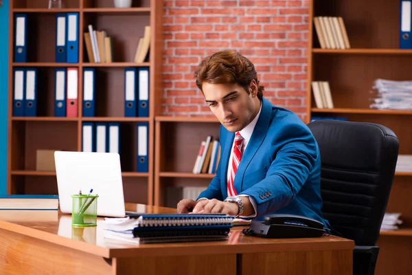 Joven empleado guapo sentado en la oficina — Foto de Stock