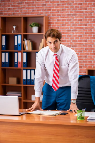 Joven empleado guapo sentado en la oficina — Foto de Stock