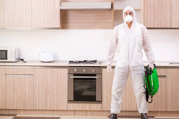 Contratante profissional fazendo controle de pragas na cozinha — Fotografia de Stock