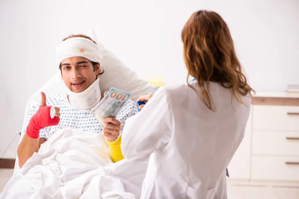 Молодой врач осматривает раненого пациента — стоковое фото
