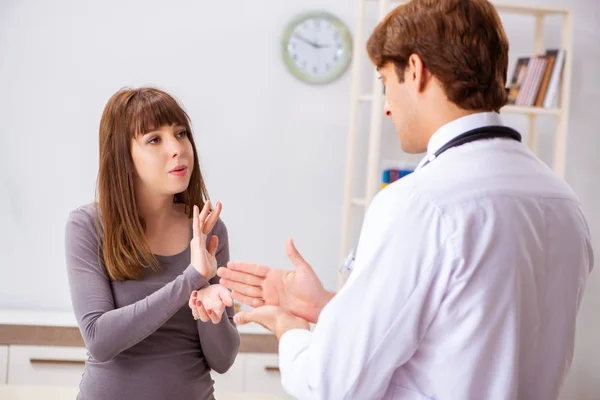 Dövstum kvinna patient besöker unga manliga läkare — Stockfoto