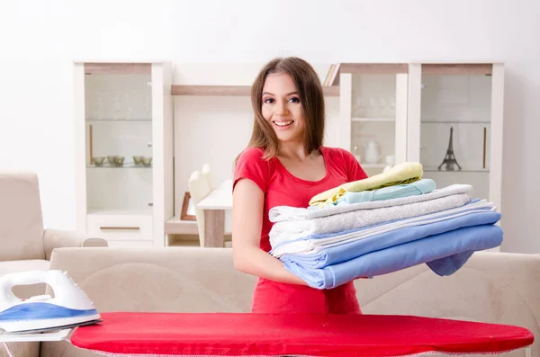 Jeune belle femme repassage à la maison — Photo