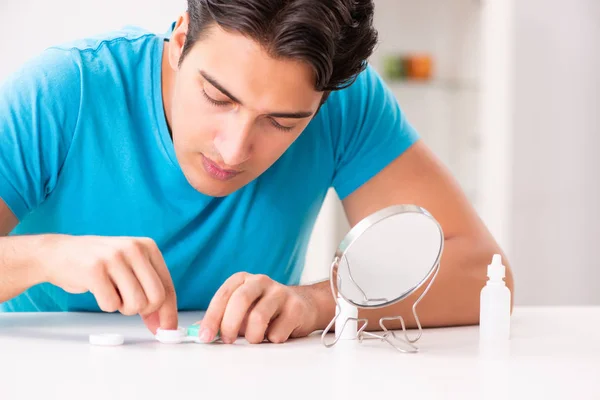 Homem tentando lentes de contato em casa — Fotografia de Stock