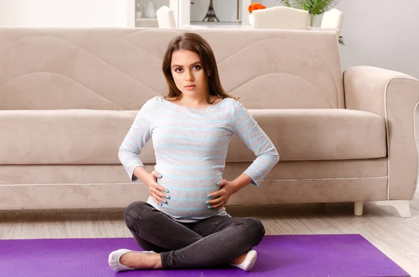 Giovane donna incinta che fa esercizi sportivi a casa — Foto Stock