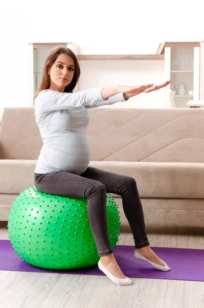 Jonge zwangere vrouw sport oefeningen thuis doen — Stockfoto