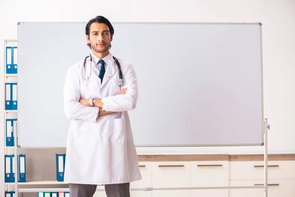 Mladý lékař před tabulí — Stock fotografie