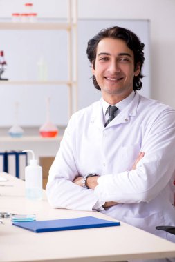 Laboratuvarda çalışan yakışıklı bir kimyager. 