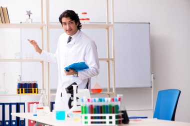 Laboratuvarda çalışan yakışıklı bir kimyager. 