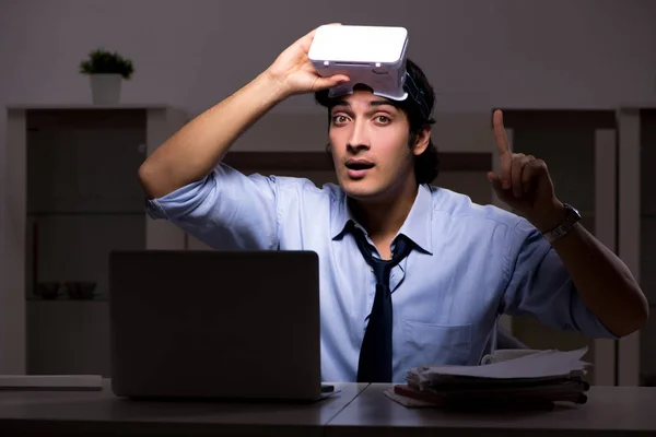Ung anställd med virtuella glasögon på natten på kontoret — Stockfoto