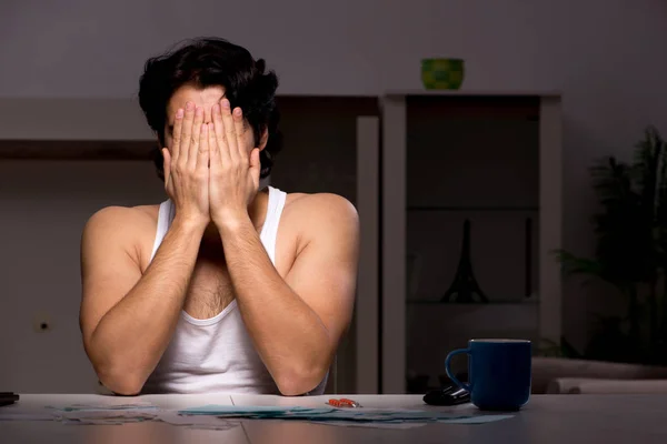 Young man calculating expences night at home — Stock Photo, Image