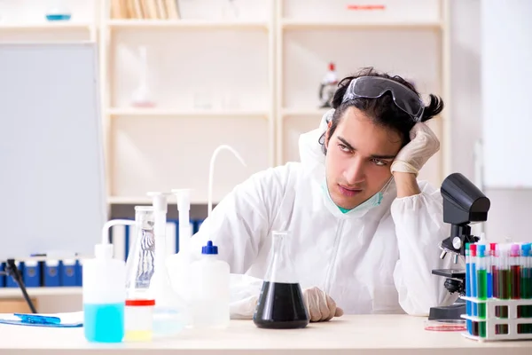 Jonge knappe chemicus die in het lab werkt — Stockfoto