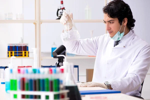 Jonge knappe chemicus die in het lab werkt — Stockfoto