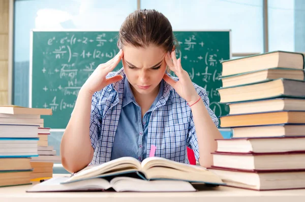 Étudiante avec de nombreux livres assis dans la salle de classe — Photo