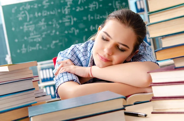 Studentin mit vielen Büchern im Klassenzimmer — Stockfoto