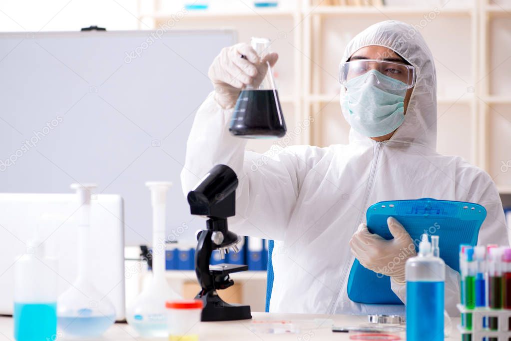 Young handsome chemist working in the lab 