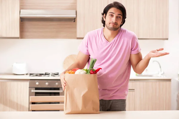 Joven hombre guapo con verduras en la cocina —  Fotos de Stock