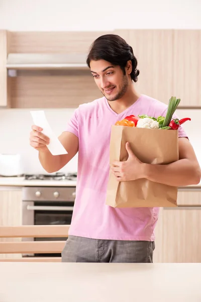 Giovane bell'uomo con verdure in cucina — Foto Stock