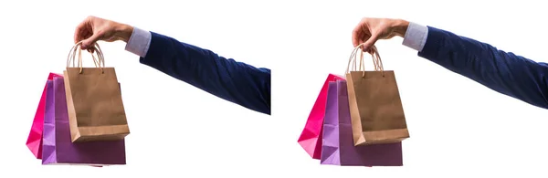 Mano che tiene le borse della spesa con lo shopping di Natale sul retro bianco — Foto Stock