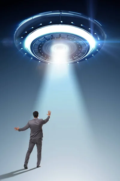 Flying saucer abducting young businessman — Stock Photo, Image