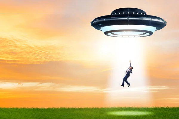 Flying saucer abducting young businessman — Stock Photo, Image