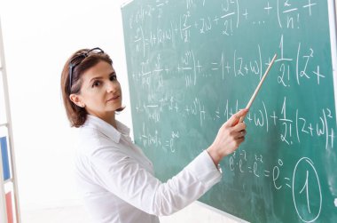 Kara tahta önünde kadın matematik öğretmeni 