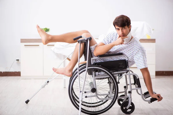 Mladý pohledný muž na vozíku v nemocnici — Stock fotografie