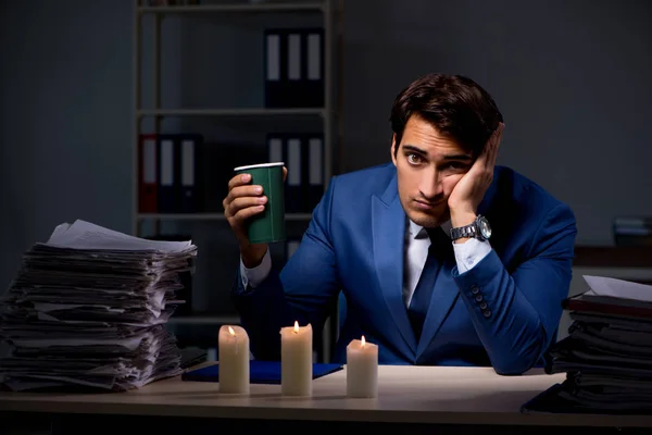 Businessman working late in office with candle light