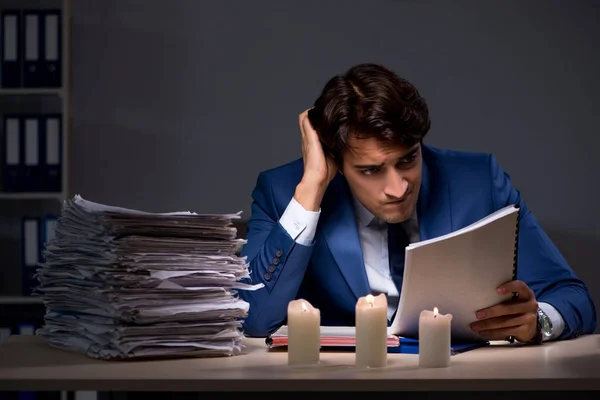 Businessman working late in office with candle light