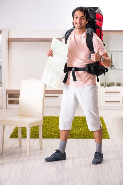 Jonge mannelijke toeristische reis thuis voorbereiden — Stockfoto