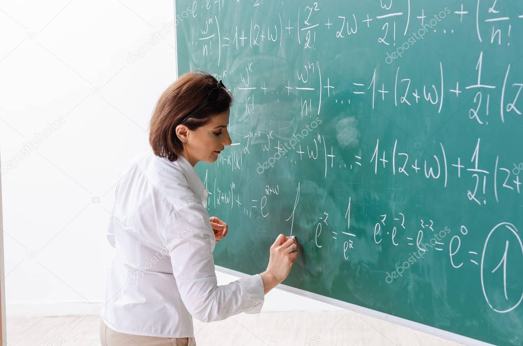 Female math teacher in front of the chalkboard 