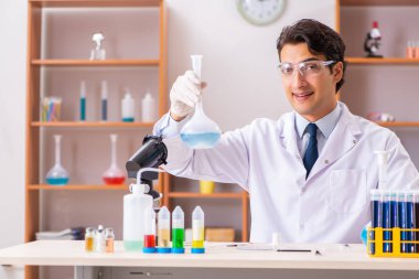 Genç yakışıklı biyokimyacı laboratuvarda çalışıyor. 