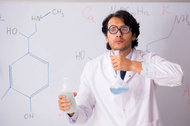 Beyaz tahta önünde genç komik kimyager 
