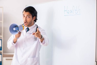 Genç doktor beyaz tahtanın önünde. 